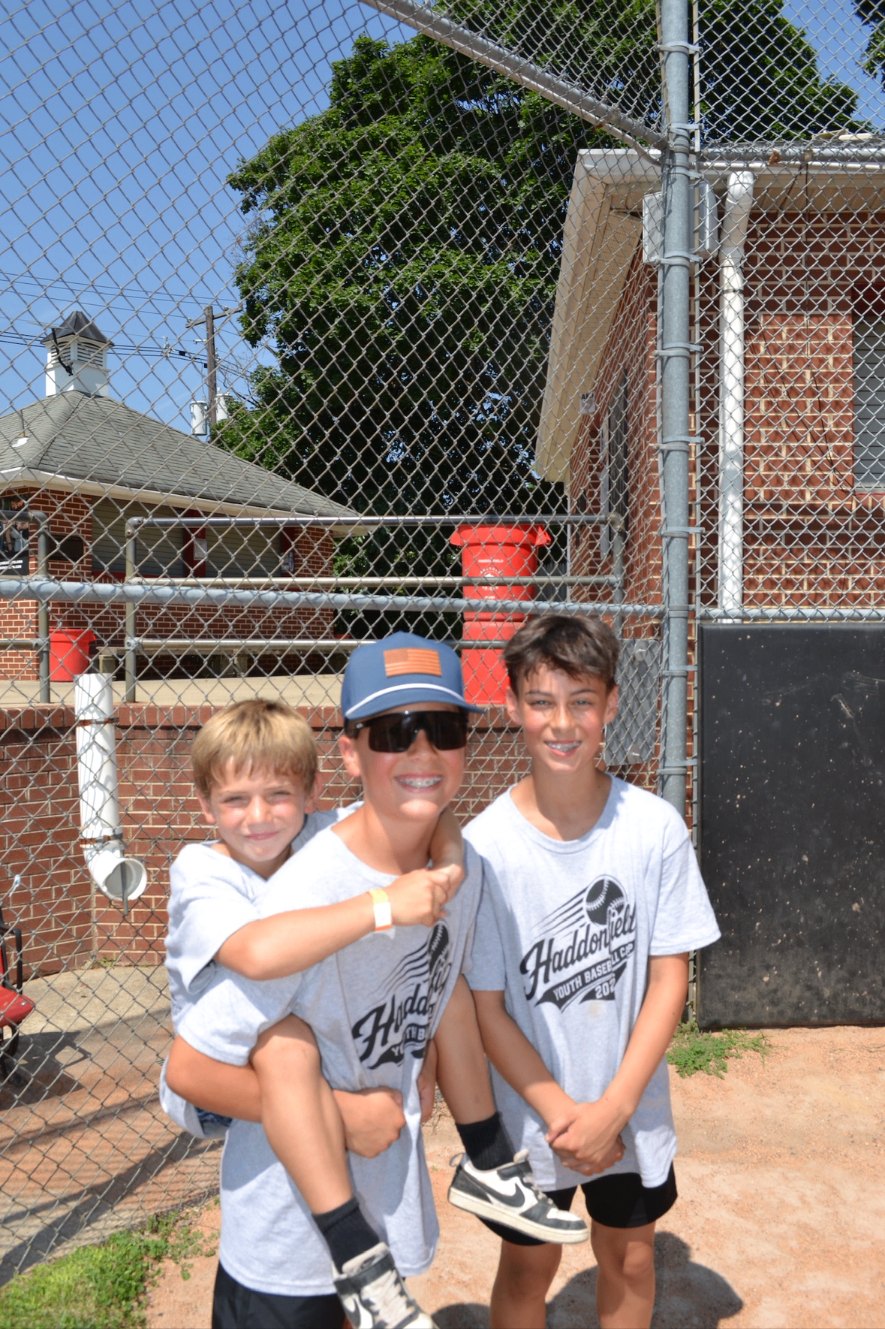 Three campers laughing together in Haddonfield Youth Baseball Camp shirts