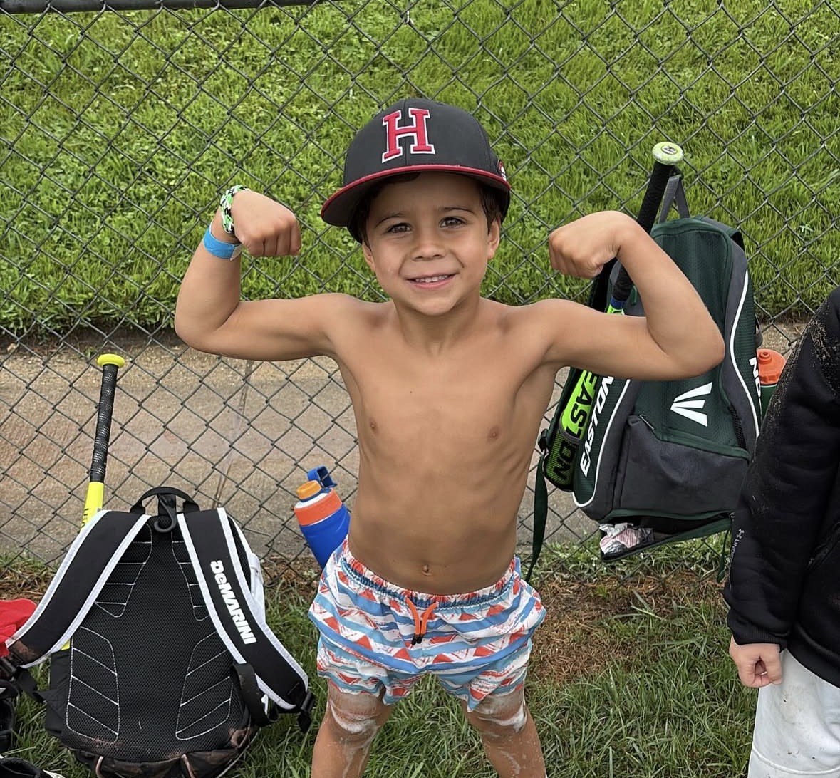 Young camper flexing after a session on the field